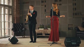 Ο αοιδός της Jazz χτυπά τα δάχτυλα στη σκηνή, saxophonist στα μαύρα παιχνίδια κοστουμιών ντουέτο απόθεμα βίντεο Ο αοιδός της Jazz χτυπά τα δάχτυλα στη σκηνή, saxophonist στα μαύρα παιχνίδια κοστουμιών ντουέτο απόθεμα βίντεο