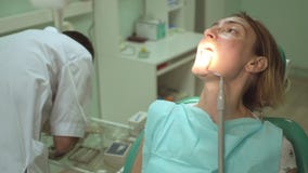 Ο αρσενικός οδοντίατρος μεταχειρίζεται ένα δόντι του όμορφου θηλυκού ασθενή στην οδοντική κλινική χρησιμοποιώντας τον ειδικό εξοπ απόθεμα βίντεο Ο αρσενικός οδοντίατρος μεταχειρίζεται ένα δόντι του όμορφου θηλυκού ασθενή στην οδοντική κλινική χρησιμοποιώντας τον ειδικό εξοπ απόθεμα βίντεο