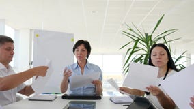 Ο διοικητικός συνεργάτης με τα φύλλα του εγγράφου διανέμει τις αναθέσεις για τους συναδέλφους στο άσπρο γραφείο φιλμ μικρού μήκους Ο διοικητικός συνεργάτης με τα φύλλα του εγγράφου διανέμει τις αναθέσεις για τους συναδέλφους στο άσπρο γραφείο φιλμ μικρού μήκους