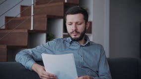 Ο επιχειρηματίας κάθεται στον καναπέ και εργάζεται με τα έγγραφα φιλμ μικρού μήκους Ο επιχειρηματίας κάθεται στον καναπέ και εργάζεται με τα έγγραφα φιλμ μικρού μήκους