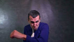 Ο επιχειρηματίας παλεύει το εγκιβωτίζοντας άτομο που κυματίζει σε αργή κίνηση όπλων του φιλμ μικρού μήκους Ο επιχειρηματίας παλεύει το εγκιβωτίζοντας άτομο που κυματίζει σε αργή κίνηση όπλων του φιλμ μικρού μήκους