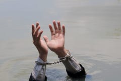 Ο επιχειρηματίας συλλήφθηκε με τις χειροπέδες και το πνίξιμο στοκ εικόνες Ο επιχειρηματίας συλλήφθηκε με τις χειροπέδες και το πνίξιμο στοκ εικόνες