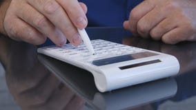 Ο επιχειρηματίας υπολογίζει τη χρησιμοποίηση μιας μάνδρας και μιας μηχανής προσθήκης στοκ φωτογραφίες Ο επιχειρηματίας υπολογίζει τη χρησιμοποίηση μιας μάνδρας και μιας μηχανής προσθήκης στοκ φωτογραφίες