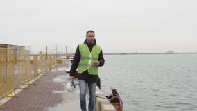 Ο εργαζόμενος θαλάσσιων λιμένων είναι στο λιμένα απόθεμα βίντεο Ο εργαζόμενος θαλάσσιων λιμένων είναι στο λιμένα απόθεμα βίντεο