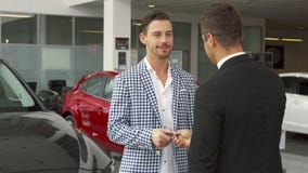 Ο ευτυχής αγοραστής και ο πωλητής κάνουν μια διαπραγμάτευση της αγοράς ενός αυτοκινήτου στοκ φωτογραφία Ο ευτυχής αγοραστής και ο πωλητής κάνουν μια διαπραγμάτευση της αγοράς ενός αυτοκινήτου στοκ φωτογραφία