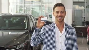 Ο ευτυχής νέος αγοραστής αυτοκινήτων παρουσιάζει πιστωτική κάρτα του στοκ εικόνες Ο ευτυχής νέος αγοραστής αυτοκινήτων παρουσιάζει πιστωτική κάρτα του στοκ εικόνες