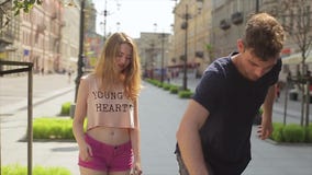 Ο ευτυχής φίλος αγκαλιάζει δικών του το κομψό κορίτσι και παρουσιάζει να κάνει σκέιτ μπορντ στην slo-Mo Ο ευτυχής φίλος αγκαλιάζει δικών του το κομψό κορίτσι και παρουσιάζει να κάνει σκέιτ μπορντ στην slo-Mo