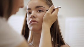 Ο καλλιτέχνης Makeup εφαρμόζει τη σκιά ματιών, τέλειο βράδυ makeup Redhead κορίτσι ομορφιάς με το τέλειες δέρμα και τις φακίδες απόθεμα βίντεο Ο καλλιτέχνης Makeup εφαρμόζει τη σκιά ματιών, τέλειο βράδυ makeup Redhead κορίτσι ομορφιάς με το τέλειες δέρμα και τις φακίδες απόθεμα βίντεο