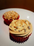 Ο καφές cupcakes στα κόκκινα φλυτζάνια εγγράφου που διακοσμήθηκαν με την κρέμα καφέ αυξήθηκε και ασημένιο σιτάρι ζάχαρης στην κορ στοκ φωτογραφία Ο καφές cupcakes στα κόκκινα φλυτζάνια εγγράφου που διακοσμήθηκαν με την κρέμα καφέ αυξήθηκε και ασημένιο σιτάρι ζάχαρης στην κορ στοκ φωτογραφία