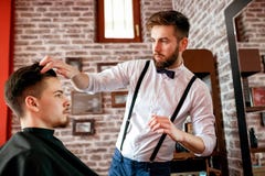 Ο κομμωτής ρυθμίζει την τρίχα ένας πελάτης με ένα πήκτωμα Στοκ εικόνα με δικαίωμα ελεύθερης χρήσης Ο κομμωτής ρυθμίζει την τρίχα ένας πελάτης με ένα πήκτωμα Στοκ εικόνα με δικαίωμα ελεύθερης χρήσης