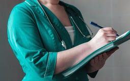 Ο κτηνίατρος ταΐζει ένα ρακούν από ένα μπουκάλι στοκ εικόνα Ο κτηνίατρος ταΐζει ένα ρακούν από ένα μπουκάλι στοκ εικόνα