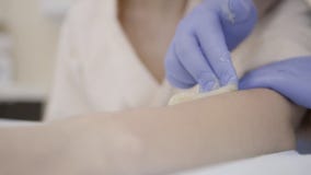 Ο κύριος κάνει το epilation του χεριού χρησιμοποιώντας την κόλλα ζάχαρης στο σαλόνι στο εσωτερικό φιλμ μικρού μήκους Ο κύριος κάνει το epilation του χεριού χρησιμοποιώντας την κόλλα ζάχαρης στο σαλόνι στο εσωτερικό φιλμ μικρού μήκους