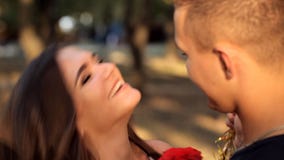 Ο νεαρός άνδρας συναντά romantically το κορίτσι του σε ένα πάρκο διακοπών φιλμ μικρού μήκους Ο νεαρός άνδρας συναντά romantically το κορίτσι του σε ένα πάρκο διακοπών φιλμ μικρού μήκους