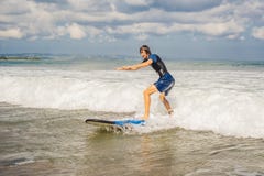 Ο νεαρός άνδρας, αρχάριος Surfer μαθαίνει να κάνει σερφ σε έναν αφρό θάλασσας στο Β στοκ εικόνες Ο νεαρός άνδρας, αρχάριος Surfer μαθαίνει να κάνει σερφ σε έναν αφρό θάλασσας στο Β στοκ εικόνες