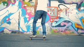 Ο νεαρός άνδρας πηδά skateboard του και αρχίζει κατά μήκος του τοίχου γκράφιτι απόθεμα βίντεο Ο νεαρός άνδρας πηδά skateboard του και αρχίζει κατά μήκος του τοίχου γκράφιτι απόθεμα βίντεο