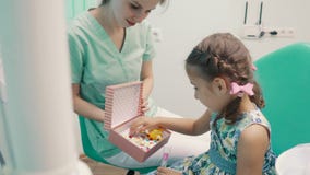 Ο οδοντίατρος παιδιών ` s διασκεδάζει το μικρό κορίτσι Ο οδοντίατρος παιδιών ` s διασκεδάζει το μικρό κορίτσι