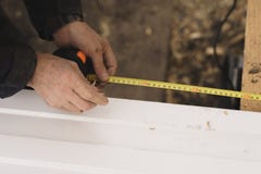 Ο οικοδόμος στα γάντια μετρά το μήκος ενός σχεδιαγράμματος μετάλλων με ένα μέτρο ταινιών στοκ φωτογραφία με δικαίωμα ελεύθερης χρήσης Ο οικοδόμος στα γάντια μετρά το μήκος ενός σχεδιαγράμματος μετάλλων με ένα μέτρο ταινιών στοκ φωτογραφία με δικαίωμα ελεύθερης χρήσης