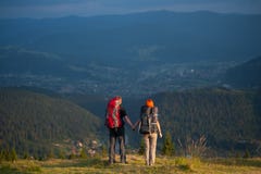 Οδοιπόροι ζεύγους με τα σακίδια πλάτης που κρατούν τα χέρια, που περπατούν στα βουνά στοκ φωτογραφίες Οδοιπόροι ζεύγους με τα σακίδια πλάτης που κρατούν τα χέρια, που περπατούν στα βουνά στοκ φωτογραφίες