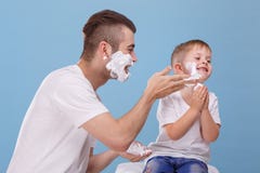 Ο πατέρας και λίγος γιος έχουν τη διασκέδαση μαζί, πατέρας με τον αφρό για το ξύρισμα, λερώνουν το πρόσωπο γιων του ` s με το ξύρ στοκ φωτογραφία Ο πατέρας και λίγος γιος έχουν τη διασκέδαση μαζί, πατέρας με τον αφρό για το ξύρισμα, λερώνουν το πρόσωπο γιων του ` s με το ξύρ στοκ φωτογραφία