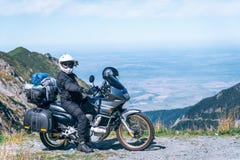 Ο ποδηλάτης κάθεται στη μοτοσικλέτα περιπέτειάς του, το τοπ βουνό στο υπόβαθρο, enduro, από το δρόμο, όμορφη άποψη, δρόμος κινδύν στοκ εικόνα με δικαίωμα ελεύθερης χρήσης Ο ποδηλάτης κάθεται στη μοτοσικλέτα περιπέτειάς του, το τοπ βουνό στο υπόβαθρο, enduro, από το δρόμο, όμορφη άποψη, δρόμος κινδύν στοκ εικόνα με δικαίωμα ελεύθερης χρήσης