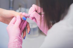 Ο πυροβολισμός κινηματογραφήσεων σε πρώτο πλάνο του μανικιουρίστα στα ρόδινα λαστιχένια γάντια κάνει τα νύχια ζωγραφικής χεριών μ Στοκ εικόνα με δικαίωμα ελεύθερης χρήσης Ο πυροβολισμός κινηματογραφήσεων σε πρώτο πλάνο του μανικιουρίστα στα ρόδινα λαστιχένια γάντια κάνει τα νύχια ζωγραφικής χεριών μ Στοκ εικόνα με δικαίωμα ελεύθερης χρήσης