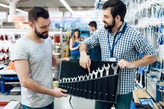 Ο πωλητής παρουσιάζει γενειοφόρο σύνολο πελατών γαλλικών κλειδιών στο κατάστημα εργαλείων δύναμης στοκ φωτογραφία με δικαίωμα ελεύθερης χρήσης Ο πωλητής παρουσιάζει γενειοφόρο σύνολο πελατών γαλλικών κλειδιών στο κατάστημα εργαλείων δύναμης στοκ φωτογραφία με δικαίωμα ελεύθερης χρήσης