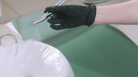 Ο σε αργή κίνηση οδοντίατρος γιατρών πυροβολισμού κινηματογραφήσεων σε πρώτο πλάνο στα αποστειρωμένα γάντια ελέγχει την εργασία τ απόθεμα βίντεο Ο σε αργή κίνηση οδοντίατρος γιατρών πυροβολισμού κινηματογραφήσεων σε πρώτο πλάνο στα αποστειρωμένα γάντια ελέγχει την εργασία τ απόθεμα βίντεο
