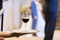Ο σερβιτόρος είναι πιάτο φροντίδας με τα γυαλιά κόκκινου κρασιού στοκ εικόνες Ο σερβιτόρος είναι πιάτο φροντίδας με τα γυαλιά κόκκινου κρασιού στοκ εικόνες