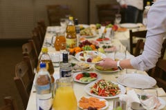 Ο σερβιτόρος φέρνει τα πιάτα στο φεστιβάλ στοκ εικόνα Ο σερβιτόρος φέρνει τα πιάτα στο φεστιβάλ στοκ εικόνα