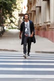 Ο τύπος Hipster που περπατά με το atitudine στη διάβαση πεζών ακούοντας που μια μουσική, πηγαίνει να λειτουργήσει στο χρόνο ημέρα στοκ φωτογραφία με δικαίωμα ελεύθερης χρήσης Ο τύπος Hipster που περπατά με το atitudine στη διάβαση πεζών ακούοντας που μια μουσική, πηγαίνει να λειτουργήσει στο χρόνο ημέρα στοκ φωτογραφία με δικαίωμα ελεύθερης χρήσης