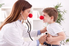Ο χαμογελώντας λατρευτός θηλυκός κλόουν γιατρών ακούει υπομονετική καρδιά στοκ φωτογραφίες με δικαίωμα ελεύθερης χρήσης Ο χαμογελώντας λατρευτός θηλυκός κλόουν γιατρών ακούει υπομονετική καρδιά στοκ φωτογραφίες με δικαίωμα ελεύθερης χρήσης