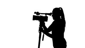 Ο χειριστής κινεί τη κάμερα Videography στο στούντιο άσπρος σκιαγραφία απόθεμα βίντεο Ο χειριστής κινεί τη κάμερα Videography στο στούντιο άσπρος σκιαγραφία απόθεμα βίντεο