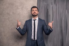 Ο όμορφος όμορφος επιχειρηματίας στέκεται στο γραφείο του που δείχνει στοκ εικόνες Ο όμορφος όμορφος επιχειρηματίας στέκεται στο γραφείο του που δείχνει στοκ εικόνες