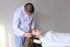 Ο όμορφος θεράπων μασάζ τύπων που κάνει το επικεφαλής μασάζ για το κορίτσι στοκ εικόνες Ο όμορφος θεράπων μασάζ τύπων που κάνει το επικεφαλής μασάζ για το κορίτσι στοκ εικόνες