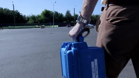 Ο όμορφος νεαρός άνδρας που δένεται με χειροπέδες στη μικρή μπλε αλεξίσφαιρη προστατευμένη περίπτωση παίρνει από τον άσπρο σύγχρο φιλμ μικρού μήκους Ο όμορφος νεαρός άνδρας που δένεται με χειροπέδες στη μικρή μπλε αλεξίσφαιρη προστατευμένη περίπτωση παίρνει από τον άσπρο σύγχρο φιλμ μικρού μήκους
