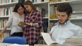 Οι άνδρες σπουδαστές διαβάζουν το βιβλίο στη βιβλιοθήκη στοκ εικόνες Οι άνδρες σπουδαστές διαβάζουν το βιβλίο στη βιβλιοθήκη στοκ εικόνες
