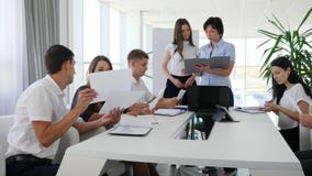 Οι άνθρωποι γραφείων με τα έγγραφα διαθέσιμα μιλούν επάνω συναντιούνται στη σύγχρονη αίθουσα συνεδριάσεων στο εμπορικό κέντρο Οι άνθρωποι γραφείων με τα έγγραφα διαθέσιμα μιλούν επάνω συναντιούνται στη σύγχρονη αίθουσα συνεδριάσεων στο εμπορικό κέντρο