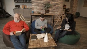 Οι άνθρωποι εργάζονται στη coworking διαστημική συνεδρίαση στις τσάντες φασολιών απόθεμα βίντεο Οι άνθρωποι εργάζονται στη coworking διαστημική συνεδρίαση στις τσάντες φασολιών απόθεμα βίντεο