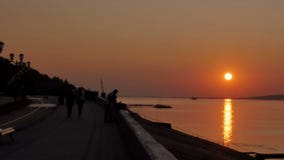 Οι άνθρωποι περπατούν στην παραλία κατά τη διάρκεια ενός όμορφου ηλιοβασιλέματος Σκιαγραφίες των ανδρών, των γυναικών και των παι απόθεμα βίντεο Οι άνθρωποι περπατούν στην παραλία κατά τη διάρκεια ενός όμορφου ηλιοβασιλέματος Σκιαγραφίες των ανδρών, των γυναικών και των παι απόθεμα βίντεο