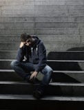 Οι άστεγοι νεαρών άνδρων έχασαν τη συνεδρίαση εργασίας στην κατάθλιψη στα συγκεκριμένα σκαλοπάτια επίγειων οδών στοκ εικόνες με δικαίωμα ελεύθερης χρήσης Οι άστεγοι νεαρών άνδρων έχασαν τη συνεδρίαση εργασίας στην κατάθλιψη στα συγκεκριμένα σκαλοπάτια επίγειων οδών στοκ εικόνες με δικαίωμα ελεύθερης χρήσης