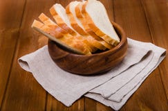 Οι δαπάνες ψωμιού περικοπών σε μια πετσέτα λινού σε ένα ξύλινο κύπελλο στοκ φωτογραφίες με δικαίωμα ελεύθερης χρήσης Οι δαπάνες ψωμιού περικοπών σε μια πετσέτα λινού σε ένα ξύλινο κύπελλο στοκ φωτογραφίες με δικαίωμα ελεύθερης χρήσης