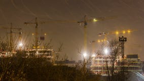 Οι γερανοί που λειτουργούν στη νύχτα και το χιόνι ανατινάζουν στην κατασκευή της κατοικήσιμης περιοχής στη ζώνη former industria απόθεμα βίντεο Οι γερανοί που λειτουργούν στη νύχτα και το χιόνι ανατινάζουν στην κατασκευή της κατοικήσιμης περιοχής στη ζώνη former industria απόθεμα βίντεο