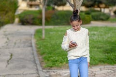 Οι ευτυχείς εργασίες παιδιών εφήβων στο τηλέφωνο, που εξετάζει το, πληρώνουν τα αγαθά Νέο blogger κοριτσιών εφήβων που διαβάζει τ στοκ φωτογραφία με δικαίωμα ελεύθερης χρήσης Οι ευτυχείς εργασίες παιδιών εφήβων στο τηλέφωνο, που εξετάζει το, πληρώνουν τα αγαθά Νέο blogger κοριτσιών εφήβων που διαβάζει τ στοκ φωτογραφία με δικαίωμα ελεύθερης χρήσης