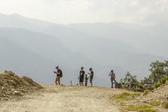 Οι ποδηλάτες στα κράνη χαλαρώνουν σε έναν δρόμο βουνών ενάντια στο σκηνικό μιας κοιλάδας βουνών στοκ φωτογραφία Οι ποδηλάτες στα κράνη χαλαρώνουν σε έναν δρόμο βουνών ενάντια στο σκηνικό μιας κοιλάδας βουνών στοκ φωτογραφία