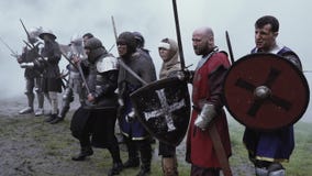 Οι πολεμιστές των μεσαιωνικών ηλικιών στέκονται πριν από τη μάχη στον καπνό απόθεμα βίντεο Οι πολεμιστές των μεσαιωνικών ηλικιών στέκονται πριν από τη μάχη στον καπνό απόθεμα βίντεο