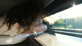 Οι ύπνοι κοριτσιών σε ένα τραίνο με ένα ανοικτό παράθυρο στο ηλιοβασίλεμα, ο αέρας φυσούν την τρίχα της, shimmer ακτίνων του ήλιο απόθεμα βίντεο Οι ύπνοι κοριτσιών σε ένα τραίνο με ένα ανοικτό παράθυρο στο ηλιοβασίλεμα, ο αέρας φυσούν την τρίχα της, shimmer ακτίνων του ήλιο απόθεμα βίντεο