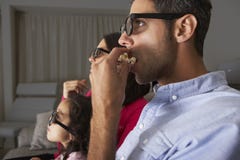 Οικογένεια που προσέχει τη TV τα τρισδιάστατα γυαλιά και Popcorn Στοκ φωτογραφία με δικαίωμα ελεύθερης χρήσης Οικογένεια που προσέχει τη TV τα τρισδιάστατα γυαλιά και Popcorn Στοκ φωτογραφία με δικαίωμα ελεύθερης χρήσης