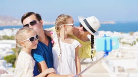 Οικογενειακές διακοπές στην Ευρώπη Γονείς και παιδιά που παίρνουν selfie την πόλη της Μυκόνου υποβάθρου φωτογραφιών στην Ελλάδα απόθεμα βίντεο Οικογενειακές διακοπές στην Ευρώπη Γονείς και παιδιά που παίρνουν selfie την πόλη της Μυκόνου υποβάθρου φωτογραφιών στην Ελλάδα απόθεμα βίντεο