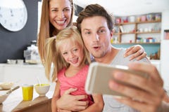 Οικογενειακή τοποθέτηση για Selfie στον πίνακα προγευμάτων στοκ φωτογραφία με δικαίωμα ελεύθερης χρήσης Οικογενειακή τοποθέτηση για Selfie στον πίνακα προγευμάτων στοκ φωτογραφία με δικαίωμα ελεύθερης χρήσης