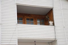 Οικοδόμηση της αττικής κατασκευής σπιτιών με τη στέγη αμιάντων, το άνετες μπαλκόνι και να πλαισιώσει την πρόσοψη στοκ εικόνες Οικοδόμηση της αττικής κατασκευής σπιτιών με τη στέγη αμιάντων, το άνετες μπαλκόνι και να πλαισιώσει την πρόσοψη στοκ εικόνες